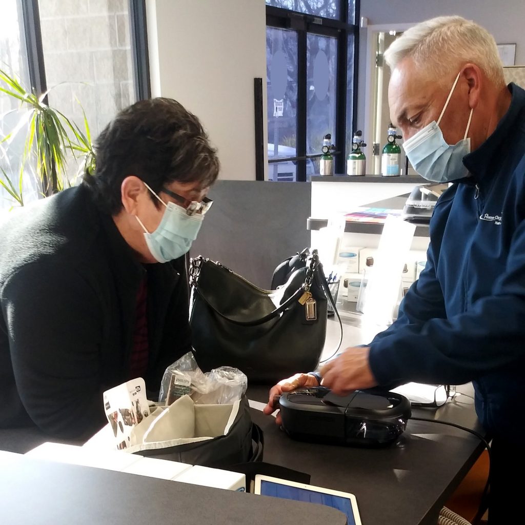 Sam Guzman, director de cuentas de Home Oxygen Company, trabaja con un cliente en una unidad de remoción de polvo.
